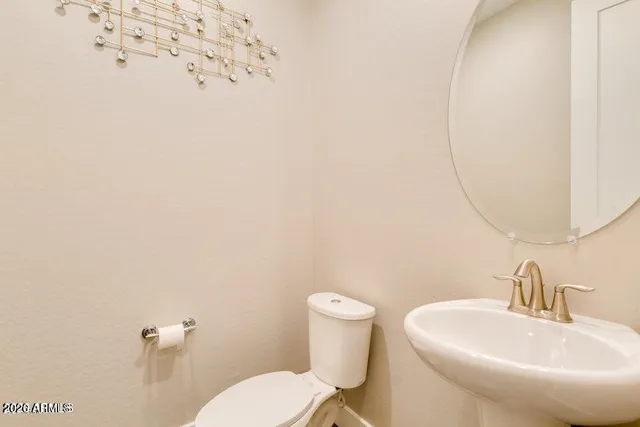 a bathroom with a sink mirror and toilet