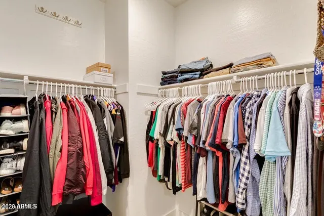 a view of walk in closet with clothes and shoes
