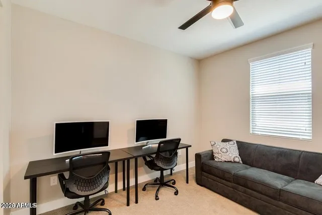 a view of a livingroom with workspace and a window