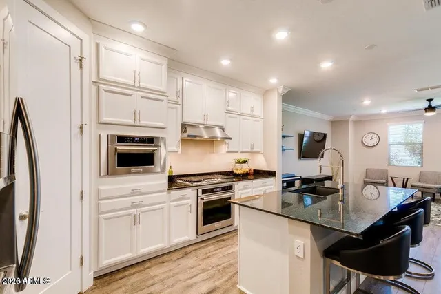 a kitchen with white cabinets and appliances