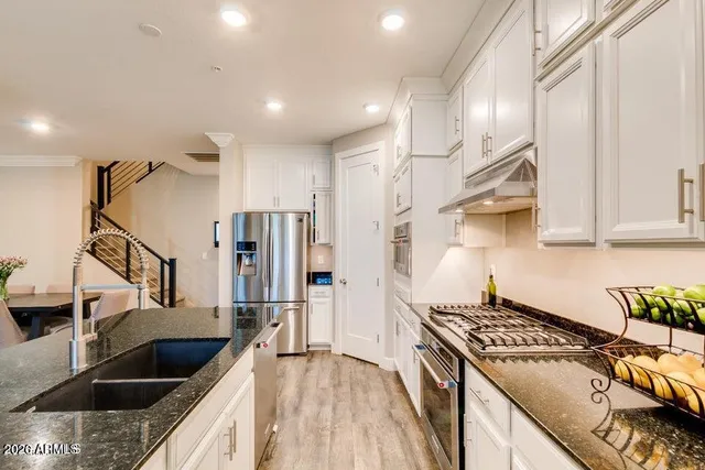 a kitchen with stainless steel appliances granite countertop a sink stove and refrigerator