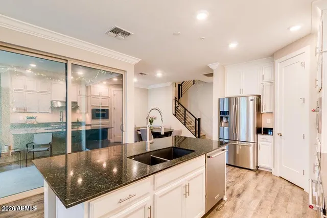 a kitchen with stainless steel appliances granite countertop a refrigerator and a sink