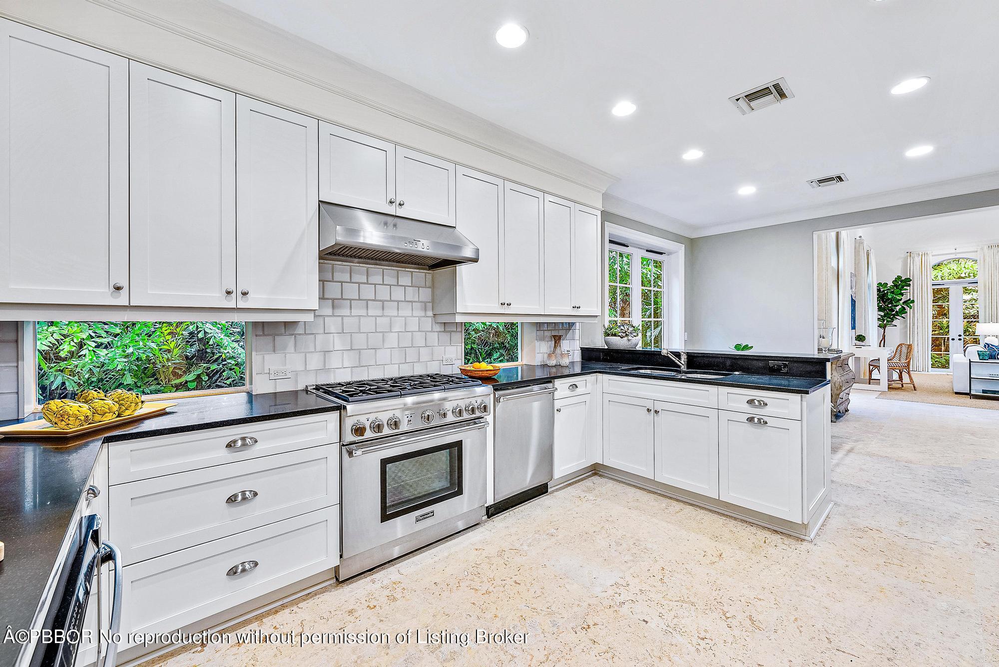 165 Root Trail Palm Beach, FL 33480 - Photo 11 of 26 a kitchen with granite countertop white cabinets and white appliances