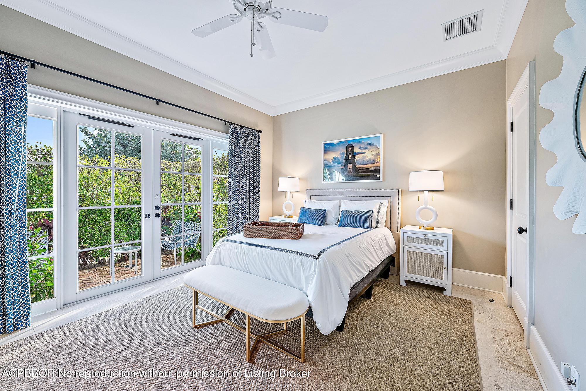 165 Root Trail Palm Beach, FL 33480 - Photo 14 of 26 a bedroom with a large bed and a chandelier