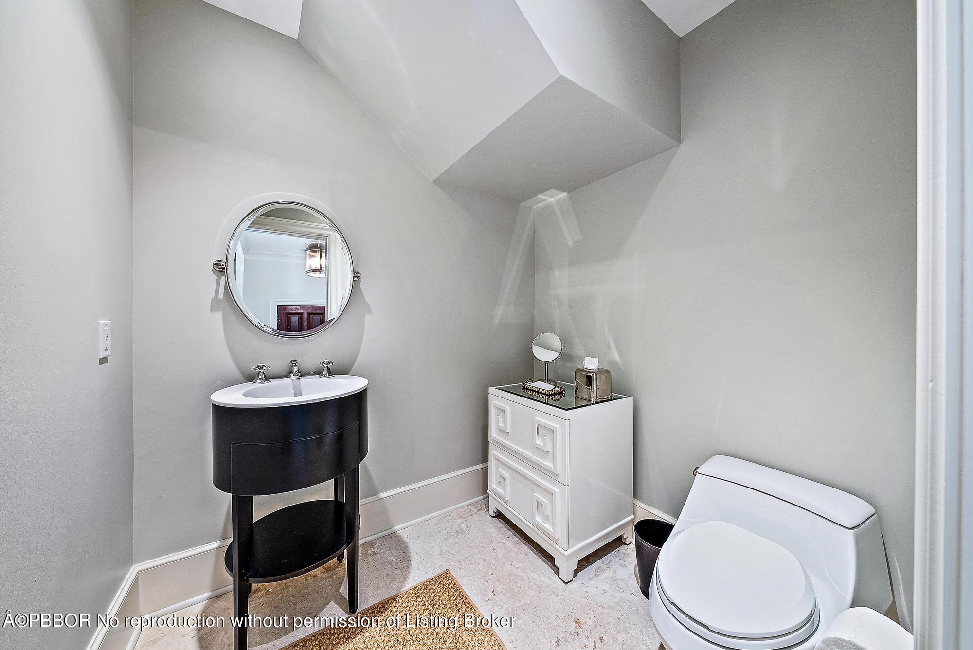 165 Root Trail Palm Beach, FL 33480 - Photo 17 of 26 a bathroom with a toilet a sink and mirror