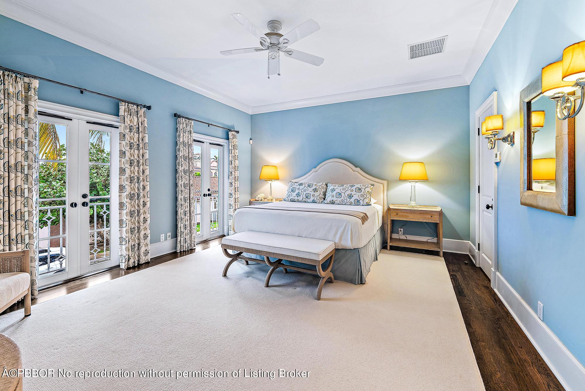 165 Root Trail Palm Beach, FL 33480 - Photo 18 of 26 a spacious bedroom with a bed a chandelier and large window