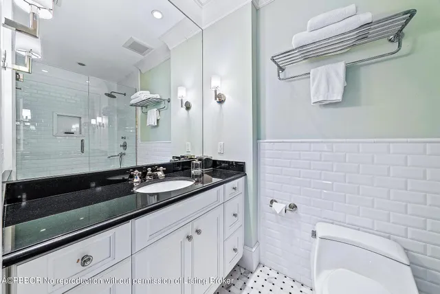 a bathroom with a granite countertop sink a toilet and shower