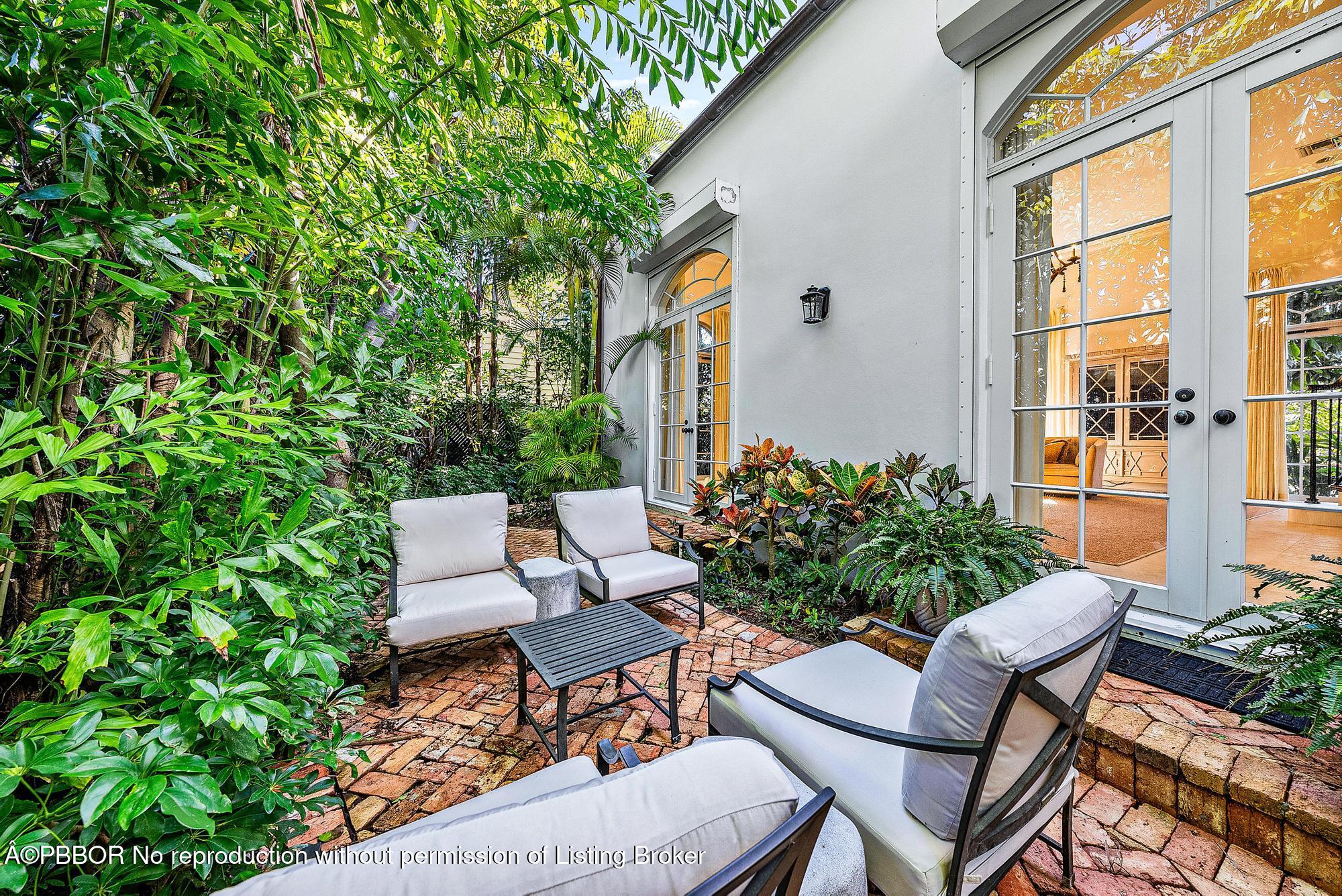 165 Root Trail Palm Beach, FL 33480 - Photo 24 of 26 a view of a chair and table in backyard of the house