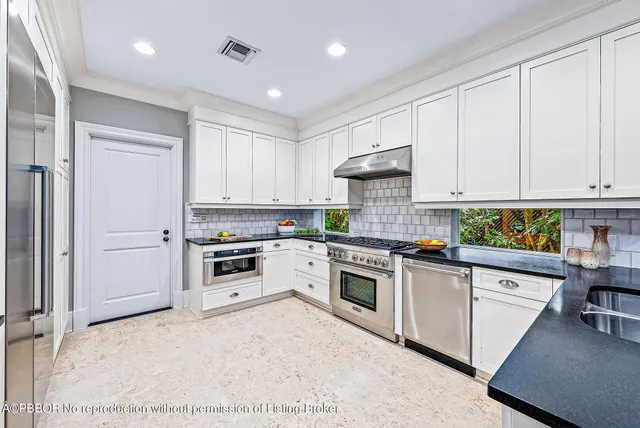 a kitchen with granite countertop white cabinets and white appliances