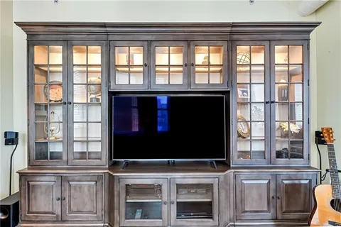 a bedroom with a bed and large window with wooden floor