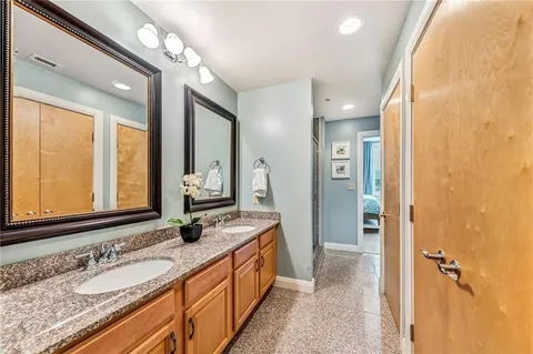 a bathroom with a granite countertop sink toilet and a mirror