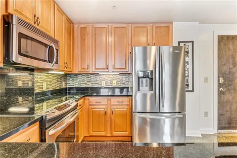 a kitchen with granite countertop a refrigerator stove and microwave