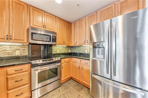 a kitchen with stainless steel appliances a refrigerator sink and microwave