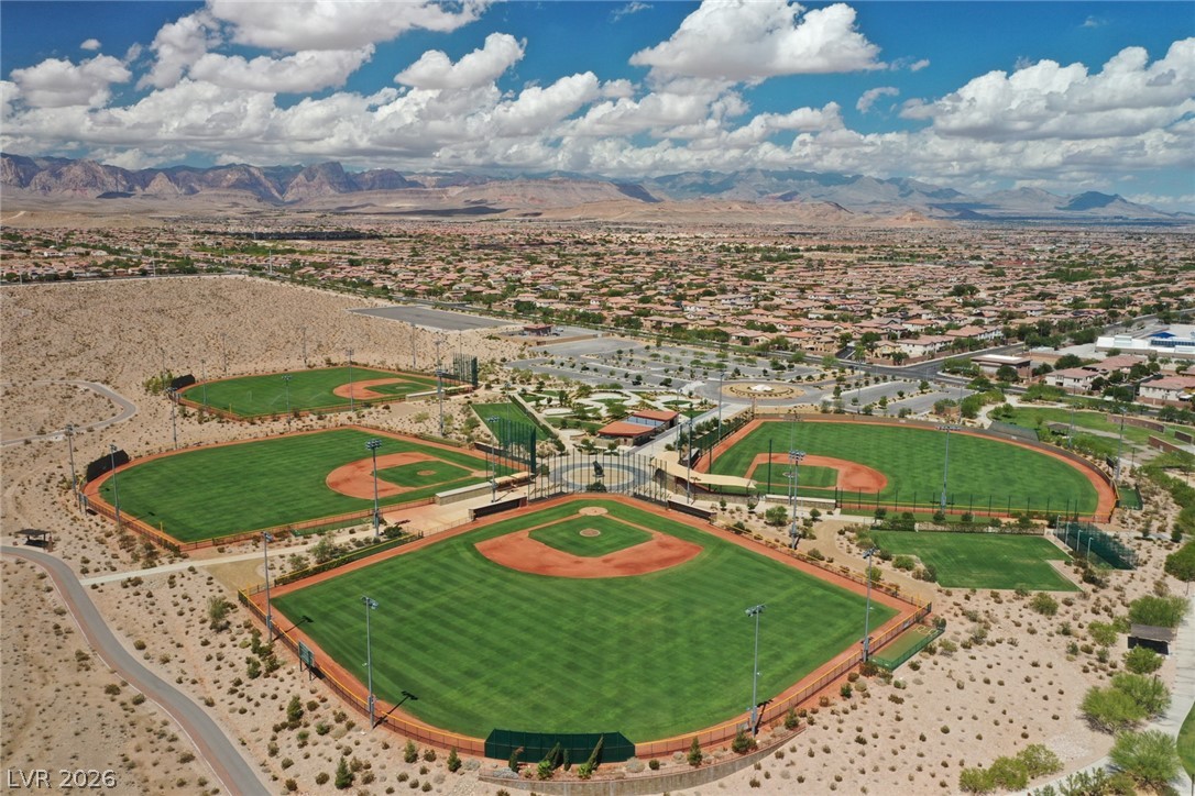 9916 Sable Point Street Las Vegas, NV 89178 - Photo 72 of 73 An aerial panorama reveals multiple baseball diamonds nestled in a vibrant community, framed by distant mountains.