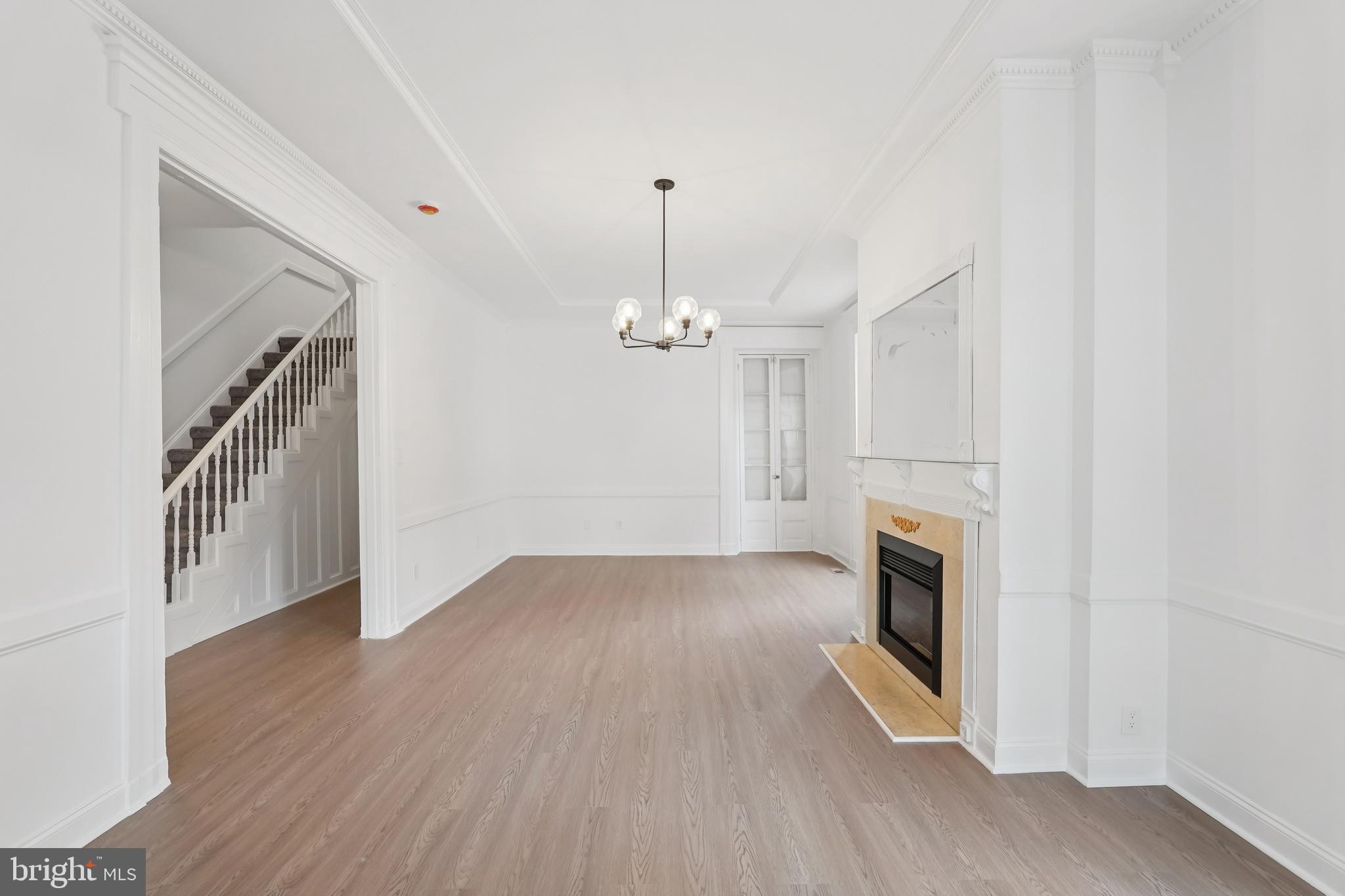 200 East Price Street Philadelphia, PA 19144 - Photo 10 of 29 an empty room with wooden floor fireplace and windows
