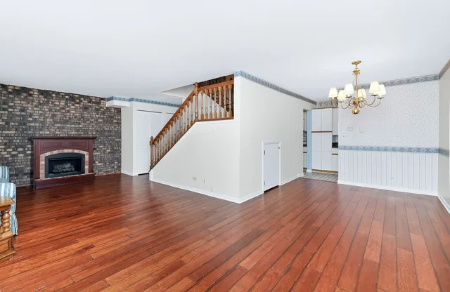 a view of a livingroom with wooden floor and a fireplace