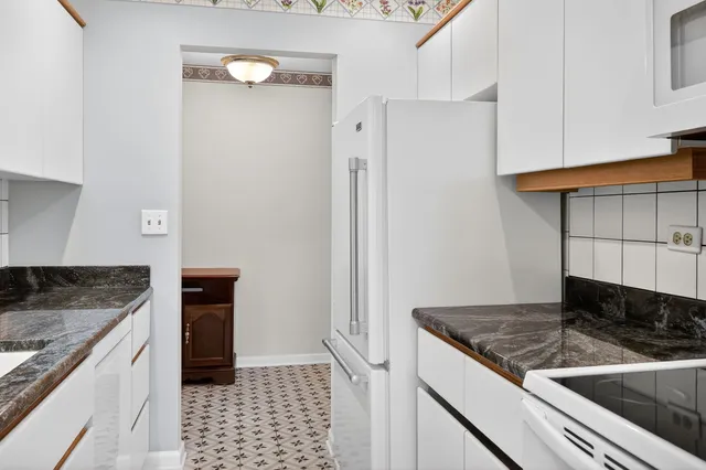 a kitchen with granite countertop a sink stove and cabinets