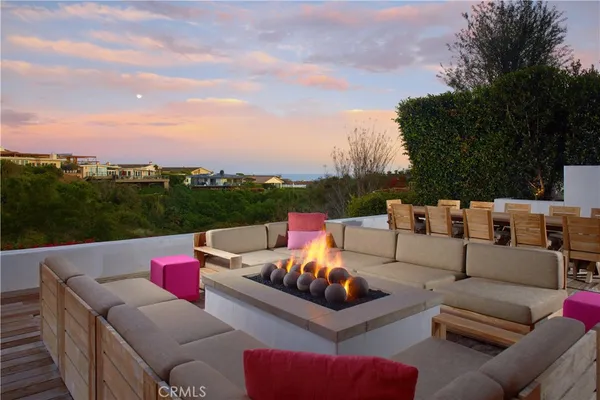 a view of a roof deck with couches and sky view