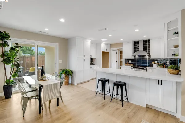 a kitchen with white cabinets and chairs