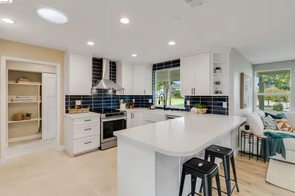a kitchen with stainless steel appliances kitchen island granite countertop a refrigerator and a stove top oven