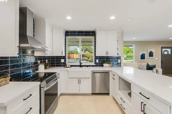 a kitchen with white cabinets and appliances