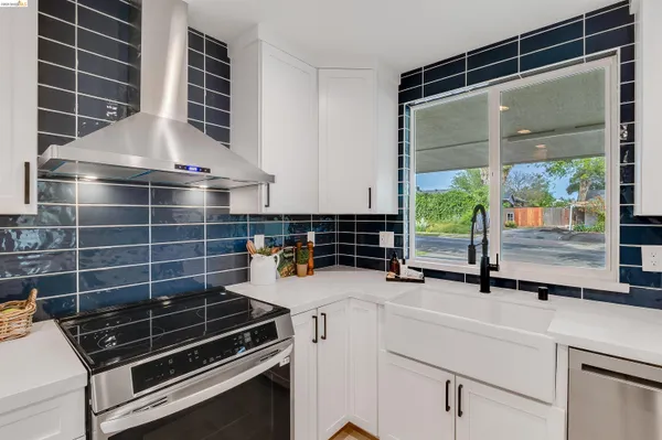 a large white kitchen with sink and white cabinets