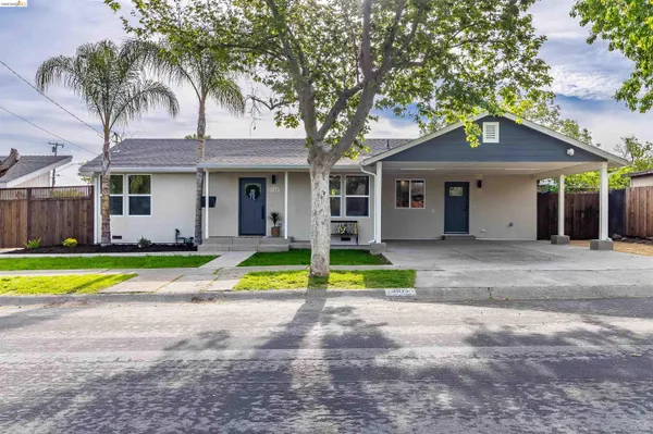 a view of a white house with a swimming pool and a large tree