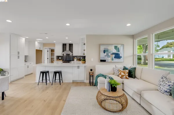 a living room with kitchen furniture and a wooden floor