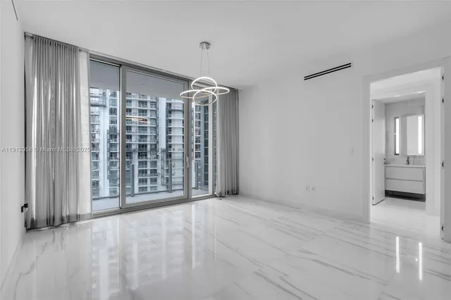 a view of an empty room with a fireplace and a window