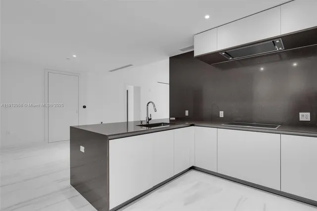 a kitchen with granite countertop a sink and cabinets