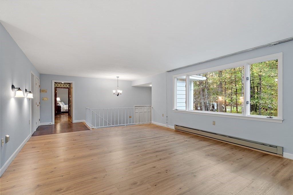 22 Sunset Rock Road Andover, MA 01810 - Photo 4 of 38 a view of an empty room with wooden floor and a window