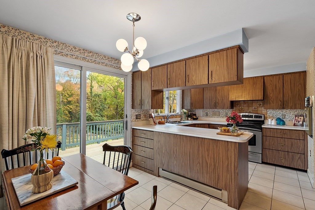 22 Sunset Rock Road Andover, MA 01810 - Photo 8 of 38 a kitchen with a stove a sink a dining table and chairs