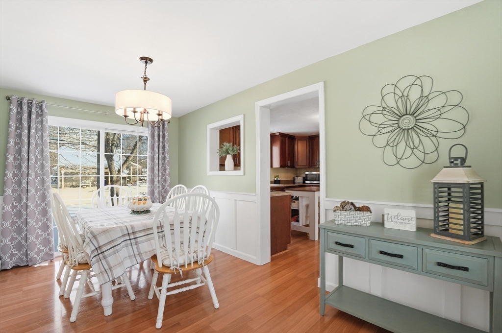 174 Columbus Drive Fall River, MA 02720 - Photo 14 of 33 a dining room with wooden floor a chandelier a wooden table and chairs