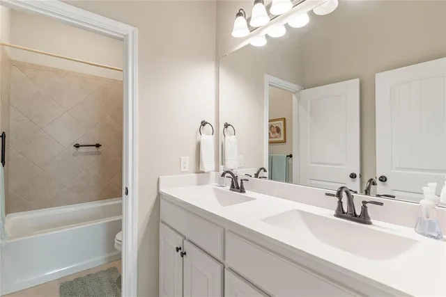 a bathroom with a sink a toilet a mirror and shower