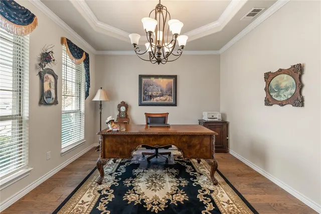 a room with chandelier fan and wooden floor