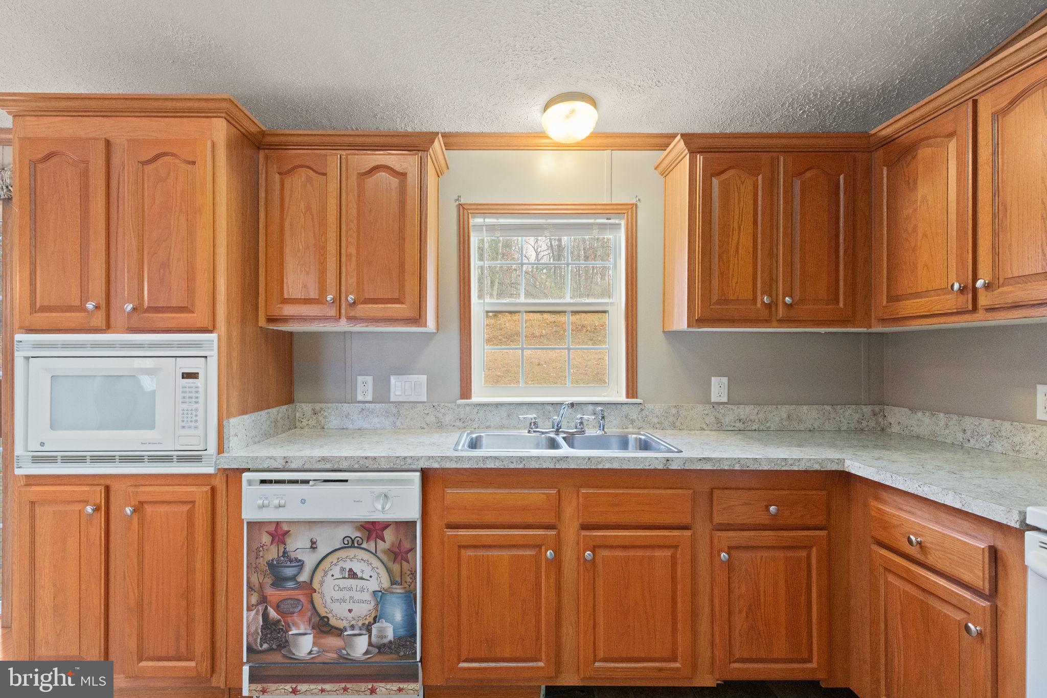16 High Ridge Road Delta, PA 17314 - Photo 5 of 32 a kitchen with granite countertop wooden cabinets a sink and dishwasher