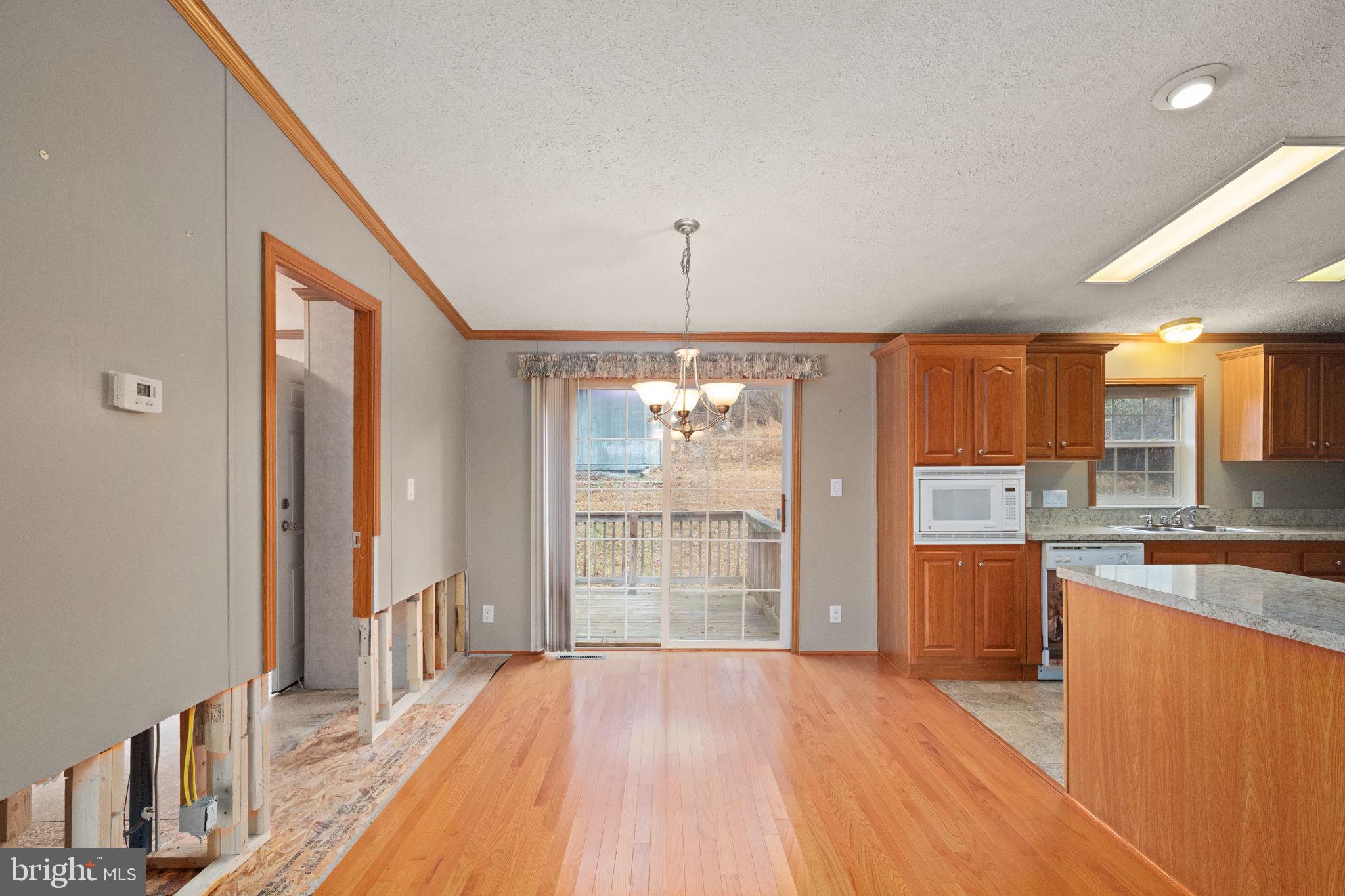 16 High Ridge Road Delta, PA 17314 - Photo 6 of 32 a open kitchen with stainless steel appliances granite countertop a refrigerator a sink dishwasher a stove and a dining table with wooden floor