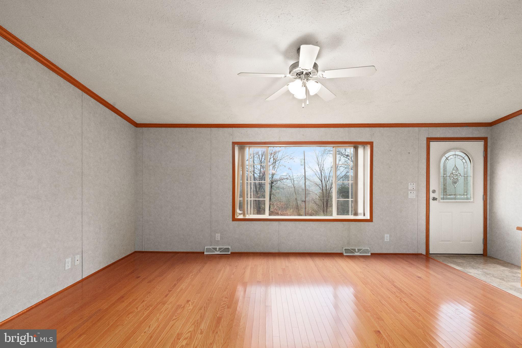 16 High Ridge Road Delta, PA 17314 - Photo 8 of 32 an empty room with wooden floor fan and windows