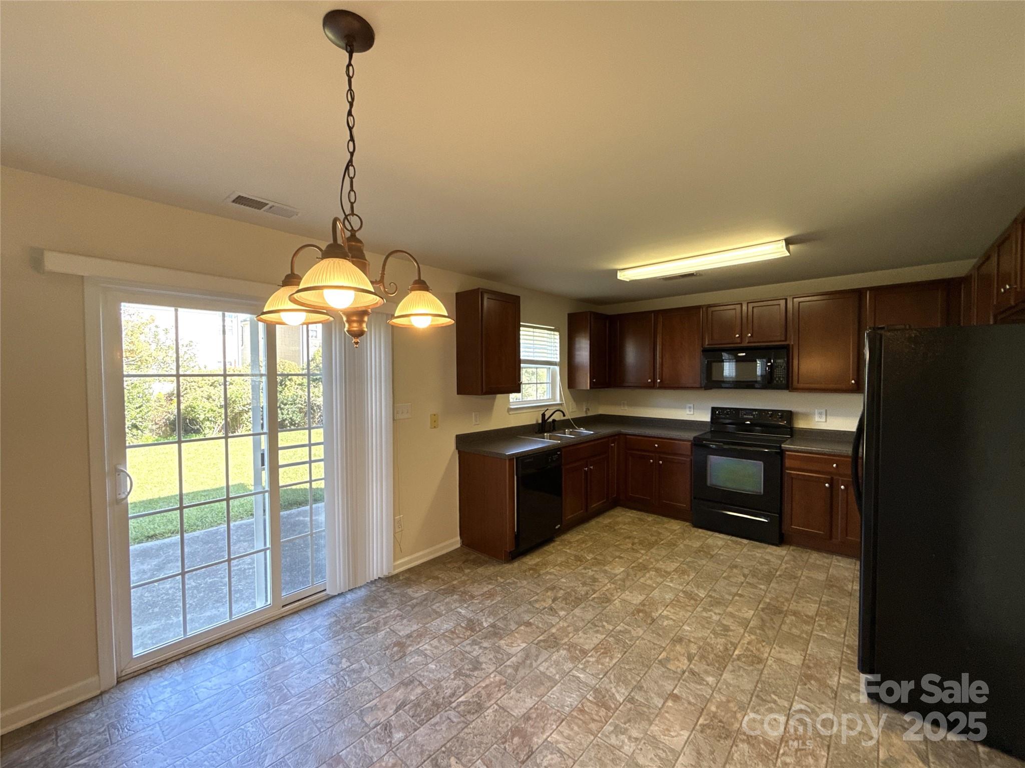 1484 Haverford Road Northwest Concord, NC 28027 - Photo 9 of 33 a kitchen with stainless steel appliances granite countertop a refrigerator a sink dishwasher a kitchen island with wooden cabinets and floor
