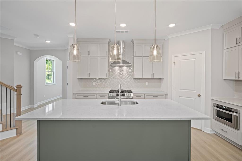 203 Retreat Lane Canton, GA 30114 - Photo 9 of 47 a kitchen with kitchen island white cabinets and stainless steel appliances