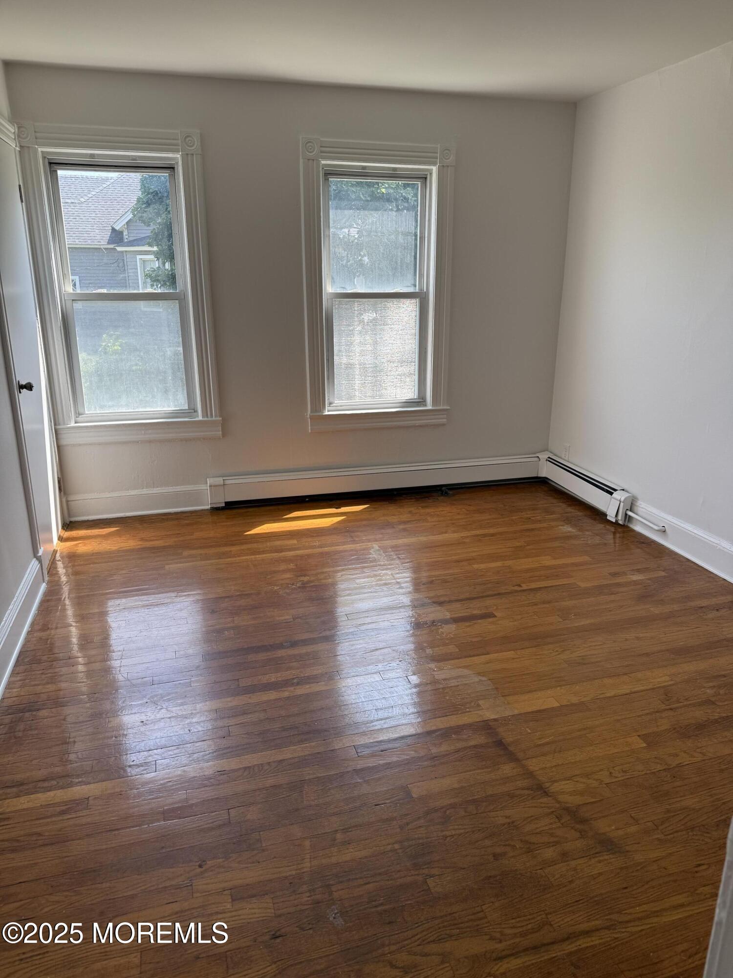 140 Franklin Avenue, Unit 3 Long Branch, NJ 07740 - Photo 7 of 14 a view of an empty room with wooden floor and a window
