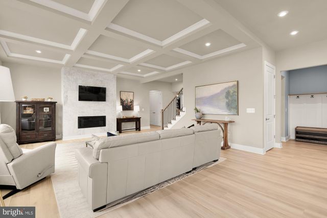 a kitchen with stainless steel appliances kitchen island granite countertop a dining table chairs and white cabinets