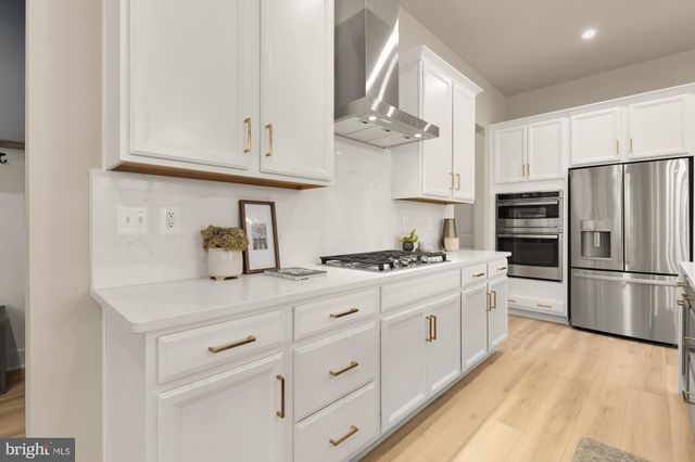 a large kitchen with kitchen island a large center island and a wooden floors
