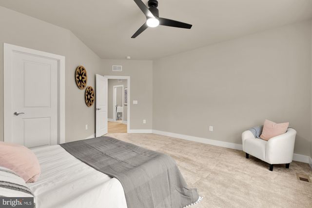 a spacious bedroom with a bed and a dresser