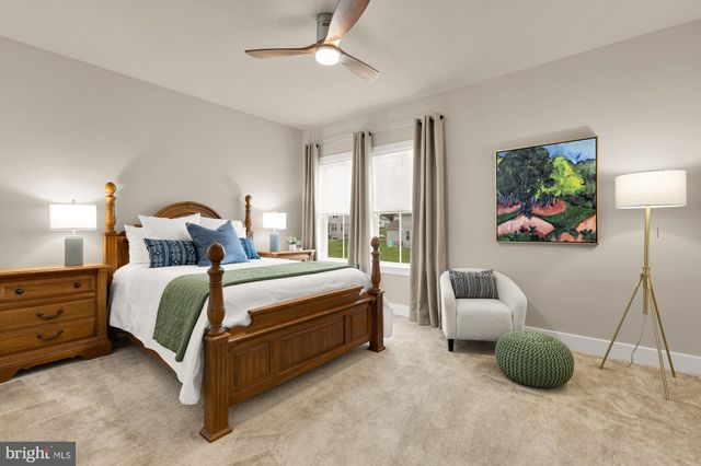 a spacious bedroom with a bed and a flat screen tv