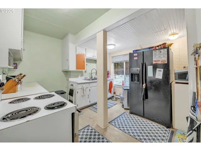 a kitchen with a stove a refrigerator and cabinets