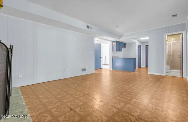 a view of empty room with a kitchen