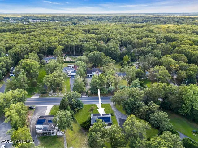 an aerial view of residential houses with outdoor space and trees
