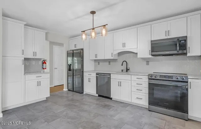 a kitchen with cabinets stainless steel appliances and a sink