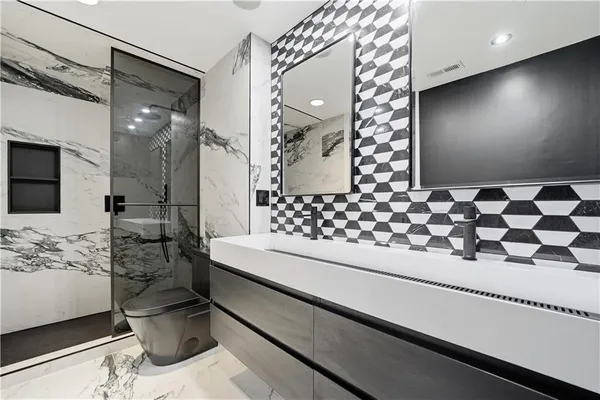 a bathroom with a double vanity sink toilet and shower